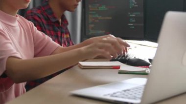 Yavaş çekim arkası yazılım geliştirici mühendisi bilgisayar programlama için birlikte çalışarak hata ayıklama kodunu çözüyor, ofiste monitörde karmaşık algoritmaları çözüyor. Filizlenen