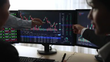 Hisse senedi borsası pazarlamasını analiz eden yavaş çekim şirketindeki yatırımcılar, kayıp için mum bar fiyatını analiz eden monitörlere bakıyor ve kazanç ve kâr elde ediyor. Filizlenen