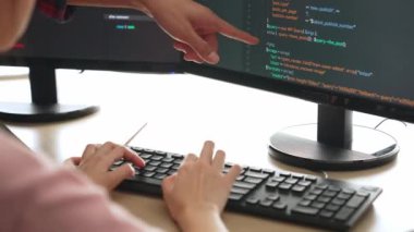 Yavaş çekimde geri uç veya yazılım geliştirici yöneticisi ekibini monitörde hata ayıklama ve karmaşık kod algoritmalarını çözmede yeni uygulama programı geliştirmede denetliyor. Filizlenen