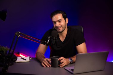 Yayıncı, fanclub dinleyicisiyle mikrofon kullanarak konuşuyor. Mor neon ışıklı modern stüdyoda yaratıcı olumlu düşünce konseptiyle canlı yayında finansal sorunları tartışıyor. Tahmin et..