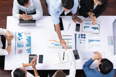 Üst düzey ofis çalışanları stratejik iş pazarlama toplantısı üzerine anlaşma yaptıktan sonra el sıkışıyor. Takım çalışması ve olumlu tutum verimli ve destekleyici bir iş yeri yaratır. Tedbirli