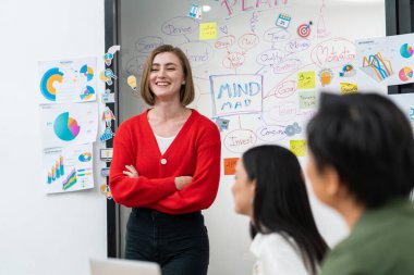 Profesyonel çekici kadın lider, modern iş toplantı odasında beyin fırtınası zihin haritalama istatistikleri ve renkli yapışkan notlar kullanarak yaratıcı pazarlama planını sunuyor. Tertemiz..