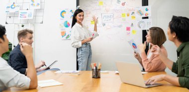 Genç ve güzel lider pazarlama stratejisini sunarken, uzman yatırımcı ve proje yöneticisi de yeni başlayan iş toplantısında iş performansını analiz etmeye çalışıyor. Çok ırklı bir grup. Tertemiz..