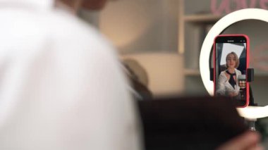 Arka plan etkileyicisi, vlog video gözden geçirme makyaj primi sosyal medya ya da blog kullanarak akıllı telefon yayınıyla canlı çekim yapıyor. İnternetteki pazarlama kaydı için kozmetik stüdyosu ışıklandırması olan kız.
