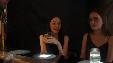 Güzel bir kadının VIP konuğunun portresi. Şık bir gece partisinde lüks bir gece kulübünde kadeh kaldırıyor. Barda oturmuş barmen atmosfer partisi yaşam tarzıyla konuşuyorum. Vinosity.