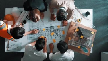 Becerikli mühendis ekibinin ev inşaatından bahsedişinin en alt görüntüsü. Mimar ya da tasarımcı grubunun planlar hakkında beyin fırtınası yapmak için tartışan ve yazan hava görüşü. Hizalama.