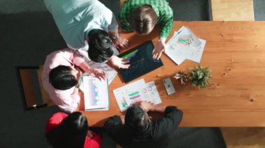 Yetenekli bir iş adamının toplantıda mali tabloya bakarken ayakta durması ve günlük giysiler giyip masadaki yatırım istatistiklerini analiz etmesi. Cemaat.