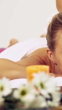 Rahat bir kadın profesyonel masaj terapistiyle lüks kaplıcalarda masaj yaptırıyor. Sağlık, şifa ve rahatlama konsepti.