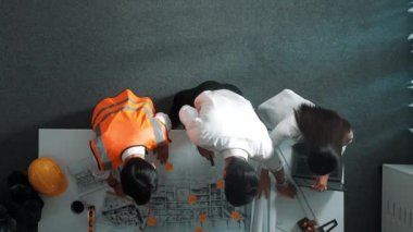 Akıllı mimar ve yetenekli inşaat mühendisi ekibinin, bina inşaatı için birlikte çalışırken proje, ekipman ve güvenlik kaskıyla toplantı masasında durmasının en iyi görüntüsü. Hizalama.