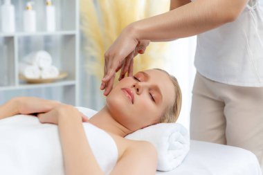 Kafkasyalı kadın stres önleyici kafa masajından ve lüks tatil beldesi ya da otel spa salonundaki modern ışık ortamında yüz güzelliği eğlencelerini şımartmaktan hoşlanıyor. Sessiz.