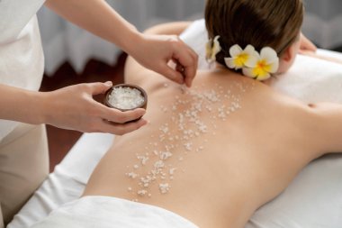 Lüks spa salonlarında sıcak mum ışığında cilt bakımı yaptıran kadın müşteri. Sağlık Spa vücut fırçasında tuz temizleme güzellik tedavisi. Sessiz.