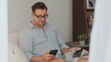 Orta yaşlı bir adam, iş için telefon arama verilerini kullanarak, çocukları iyi bir yetişkin ya da eğlence olsun diye odada kahve fincanıyla koltukta oturur. İşadamı teknolojiyi kolaylık için kullanır. Uyumsuzluk.