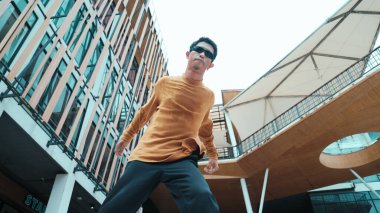 İspanyol dansçı hip hop tarzında dans ederken kameraya bakıyor. Genç ve çekici bir hippi müzik eşliğinde dans ediyor. Break dansçının hareket çekimi B-boy dansını gerçekleştirmek Açık hava sporu 2024. Hiphop.