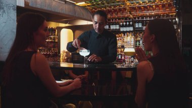 Asyalı akıllı barmen votka bardağını karıştırdı. Çiçek, lüks tezgah barında özel içki yapan güzel müşteriye servis edildi. Ferahlatıcı alkol gece hayatı lüksü. Vinosity.