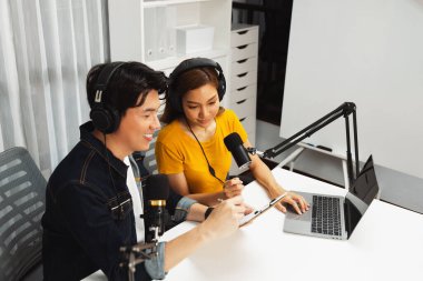 Gülümseyen radyo etkili sunucular, kulaklık takarak sosyal medya kanalından canlı yayın yapıyorlar ve sabah saatlerinde stüdyo kaydında dinleyicilere konu ve dizüstü bilgisayar üzerinden konuşuyorlar. İnfobahn.