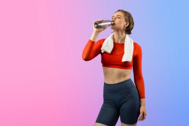 Vücut uzunluğunun tamamı atletik ve sportif genç bir kadını havluyla ve içme suyuyla izole edilmiş arka planda egzersiz yaparken çekilir. Sağlıklı aktif ve vücut bakımı yaşam tarzı.