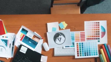 Kulaklıktan müzik dinlerken yetenekli iç dizayn grafiklerinin yukarıdan aşağı havadan görüntüsü. Proje yöneticisi kulaklıkla çalışırken ve rahat şarkılar dinlerken stüdyoda hareket ediyor. Sempozyum.