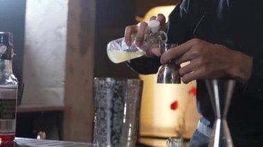 Karışık kokteyl likörünü likör karışımına döken kırpılmış barmen, özel reklamı yaratıcı, odaklı, ferahlatıcı bir vitrin haline getiriyor. Vinosity.