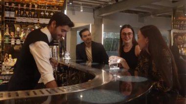 Gece kulübündeki lüks gece kulübünde, içki tezgahında çalışan akıllı barmen servisinde çift ya da arkadaş grubuyla gülen VIP müşterilere özel cin kokteyli servisi. Vinosity.