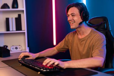 Kazanmak için çevrimiçi oyun oynayan akıllı flama makinesinin sunucu kanalı, neon ışıklı odada seçilen takım yarışması için izleyicilerle birlikte canlı yayında canlı yayında kulaklık takıyor. Bireysel.