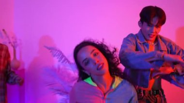 Çeşitli arkadaşlarla sokak dansı pratiği yapan profesyonel break dansçı. Çok kültürlü mutlu insanlar modern dans ederken şık giysiler giyer veya hippi tarzı dans ederler. Neon ışığı. Mutluluk.