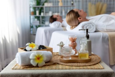 Aromaterapi masajı gündüz atmosferinde ya da spa salonunda bulanık bir kadına odak dekor ve spa aksesuarları kurarak tatil köyünde ya da otel arka planında keyifli aroma spa masajı yapan bir masaj. Sessiz.