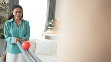 Büyükannenin elinde boru var ve göz, el koordinasyonunu geliştirmek ya da odaklanma ve konsantrasyonu arttırmak için top yuvarlama oyunu oynuyor. Yaşlı çift stresi azaltıyor. Sağlık hizmetleri. Myrmidon.