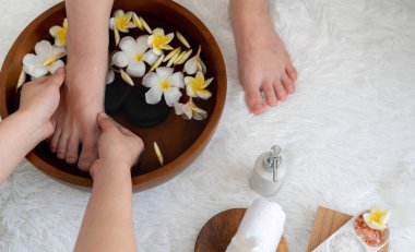 Kadınlar lüks spa salonlarında keyifli ayak masajlarına devam ederken, masör de hafif gün ışığı atmosferinde refleksoloji terapisi veya otel ayak spa 'sında. Sessiz.
