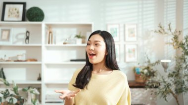 Genç girişimci, ev sahibi konumundayken anahtar fırlatıyor. Küçük işletmeleri yönetmek ya da başlamak için anahtarı taşırken kameraya özgüvenle bakan mutlu kadın satıcı. Myrmidon.