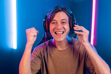 Kazanmak için çevrimiçi oyun oynayan akıllı flama makinesinin sunucu kanalı, neon ışıklı odada seçilen takım yarışması için izleyicilerle birlikte canlı yayında canlı yayında kulaklık takıyor. Bireysel.