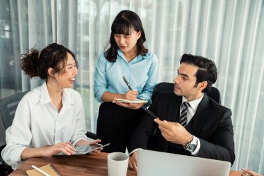 Modern ofis ortamında çalışan çeşitli etnik gruplardan çeşitli iş adamları. Üretken ve çok ırklı ofis çalışanları stratejik ticari pazarlama konusunda tartışmaya giriştiler. Habiliment