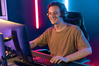 Kazanmak için çevrimiçi oyun oynayan akıllı flama makinesinin sunucu kanalı, neon ışıklı odada seçilen takım yarışması için izleyicilerle birlikte canlı yayında canlı yayında kulaklık takıyor. Bireysel.