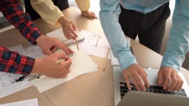 Mimarlık ve güvenlik mühendisi, modern ofiste doğruluk için mimari belge ve ölçüm aracı kullanılarak dizüstü bilgisayarın üzerinde sergilenen planlar hakkında tartıştı. - Yakın çekim. Tanımlama.