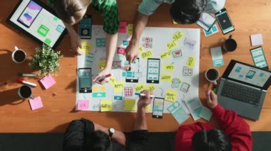 Profesyonel geliştirici ekip Ux Ui tasarımı fikrini zihin haritası kullanarak paylaşıyor. Bir grup iş adamının beyin fırtınası yapmak ya da cep telefonu arayüzü uygulamasını planlamak için birlikte çalıştıklarını görüyoruz. Cemaat.