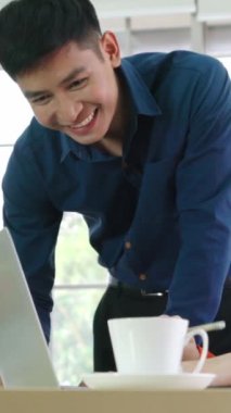 İki iş adamı toplantı odasında proje stratejisi hakkında konuşuyor. İş adamı, mali veri raporu hakkında sohbet ve tavsiyelerde bulunurken, modern işyerindeki iş arkadaşıyla proje planlamasını tartıştı.