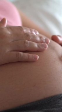 Hamile bir kadın çocuğuna bakarken kendini mutlu hissediyor. Hamile karnında bebek taşıyan hamile bir anne. Doğum öncesi bakım ve kadın hamileliği konsepti.