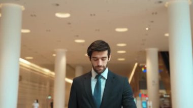 Kafkasyalı zeki iş adamı iş arkadaşını beklerken saate bakıyor. Bulanık geçmişiyle alışveriş merkezinde dikilirken yönetici takım elbise giyiyor. Yatırımcı mavi takım elbise giyer. Sevinçli..