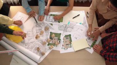 Mimari belge, ölçüm aracı ve ahşap blokların modern ofiste etrafa saçıldığı bir masa üzerinde yapı inşaatı ile ilgili mimar ve güvenlik mühendisi tartışması. Tanımlama.