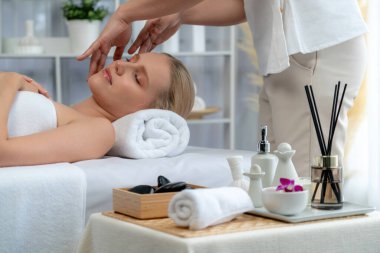 Kafkasyalı kadın stres önleyici kafa masajından ve lüks tatil beldesi ya da otel spa salonundaki modern ışık ortamında yüz güzelliği eğlencelerini şımartmaktan hoşlanıyor. Sessiz.