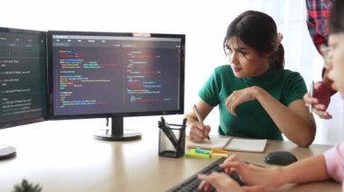 Yavaş çekim arkası yazılım geliştirici mühendisi bilgisayar programlama için birlikte çalışarak hata ayıklama kodunu çözüyor, ofiste monitörde karmaşık algoritmaları çözüyor. Filizlenen