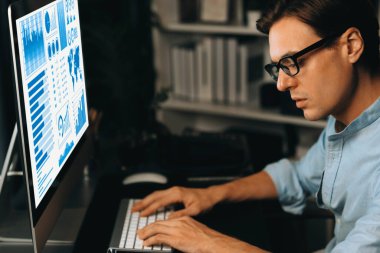 Akıllı iş adamı iş paragrafı dinamik pazarlama analizi planını analiz ediyor. Kağıt kağıtları ve bilgisayar monitörü raporlarını gece evdeki belge verileriyle karşılaştırmak için hazırlıyor. Bireysel.