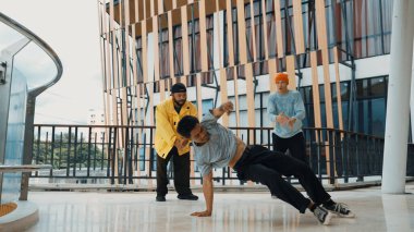 Hip hop takımı dans molası verirken, çok kültürlü bir arkadaş arkadaşını alkışlıyor ve alkışlıyor. Aktif ve enerjik sokak dansı. Açık hava sporu 2024 hiphop..