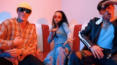 Mutlu kız kameraya bakıyor ve kanepede otururken pop müzik dinliyor. İspanyol kadın serbest stil dans ederken kameraya bakıyor neon ışıkta çeşitli arkadaşlarla dans ediyor. Mutluluk.