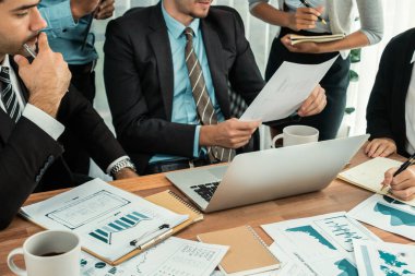 Ofis masasındaki finansal veri raporlarını analiz eden çeşitli bir grup iş analisti. Stratejik pazarlama planlaması için iş istihbarat analizine göre grafikler ve grafikler.