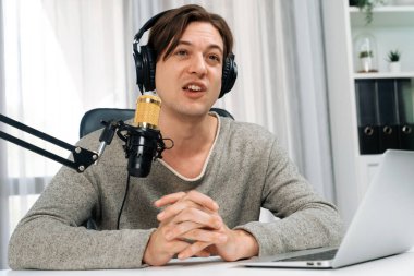 Sunucu kanalı, gülümseyen akıllı yayıncı kaydı, senaryosu ve akıllı telefonuyla sosyal medyada sohbet programı, kulaklık takarak modern ev stüdyosundaki video flamalarını kaydediyor. Bireysel.