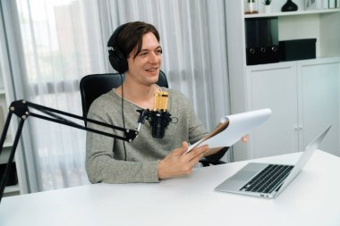 Akıllı yayıncının sunucu kanalı canlı sosyal medya yayını ile dinleyicilere senaryo okuyarak, kulaklık takarak modern ev stüdyosundaki video flamalarını kaydediyor. Bireysel.