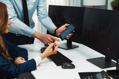 Kâr değeri değeri oranı online web sitesi uygulamasını ev ofisinde analiz etmek için notlar yazan kadınlara telefonda dinamik borsa verilerini gösteren bir işadamı eli kesilmiş. İnfobahn.