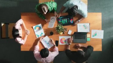 Time lapse view of smart businessman pointing and presenting at financial chart while diverse team discussing about stock market statistic at meeting table with laptop and graph document. Convocation.