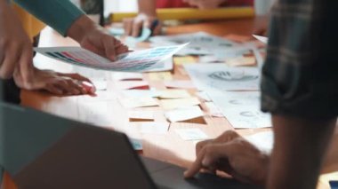 İşletme ekibinin üst görüntüsü toplantı masasına renkli yapışkan notlar ve tasarım ile grafik logo yazarak fikri açıklar. Proje yöneticisi fikri paylaşıyor ve akıllı takıma konsept sanatı anlatıyor. Sempozyum.