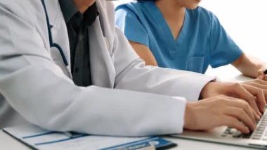 Hastane masasında birlikte çalışan ve tıbbi tedavi planlayan çeşitli profesyonel sağlık görevlileri. Takım çalışması başarılı hastalıklara ve hastalıklara yol açar. Ağır çekim. Katı.